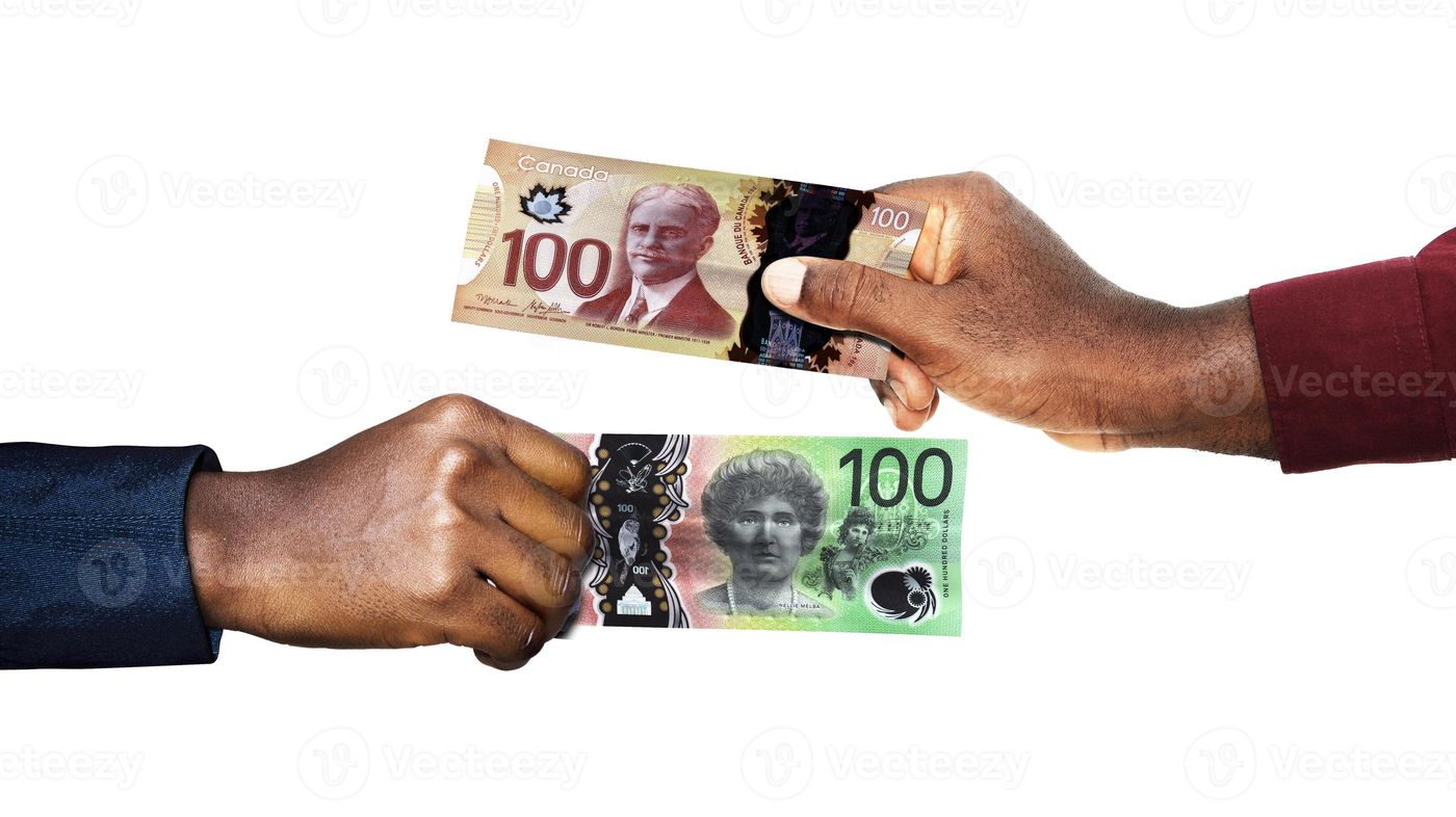 Canadian Dollar Australian Dollar currency pairing.Black African hands holding exchanging comparing two bank notes. Canada versus Australia