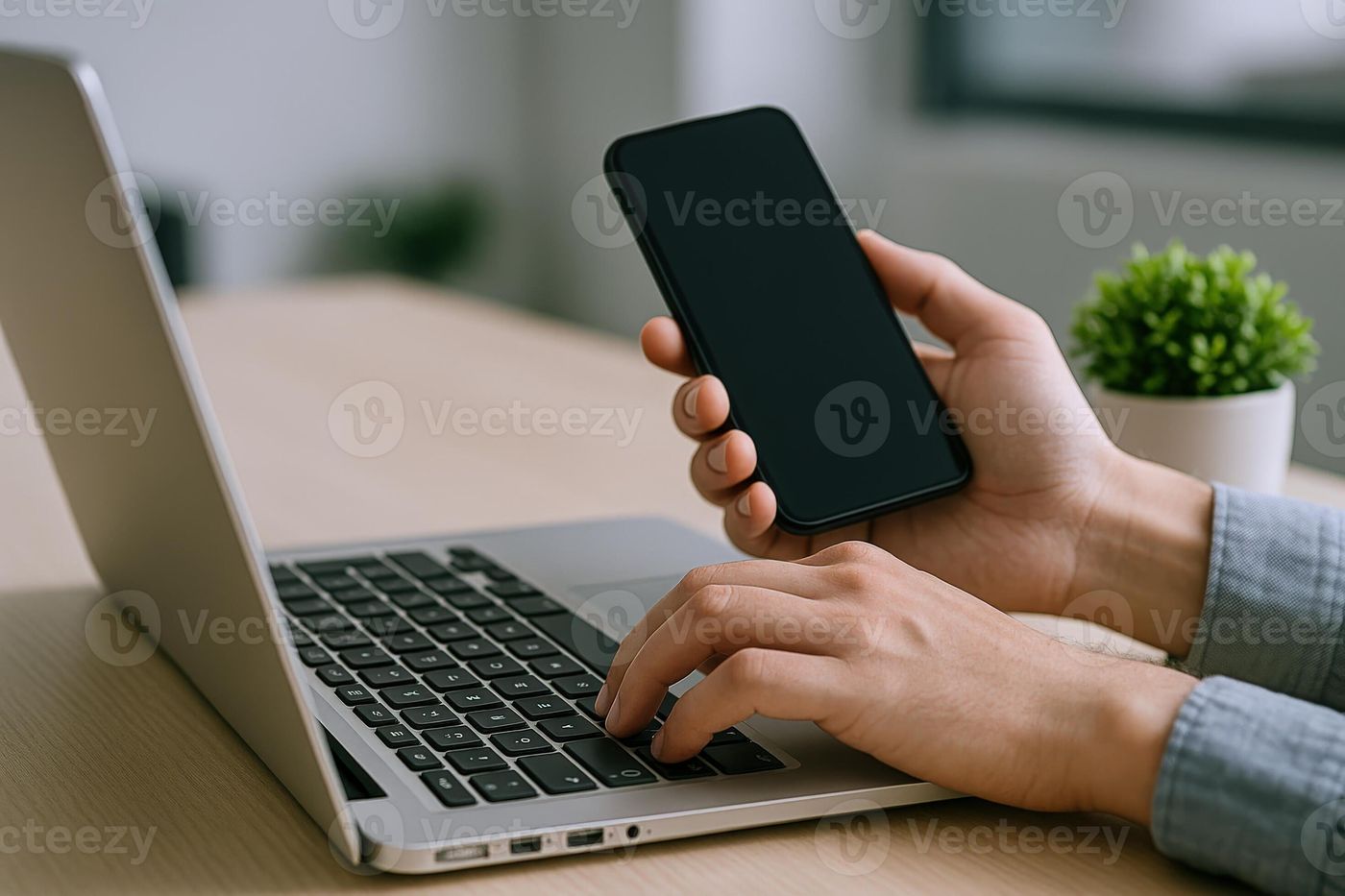 Person Typing on Laptop While Holding Smartphone for Multitasking and Connectivity in Modern Workspace 70701255 Stock Photo at Vecteezy