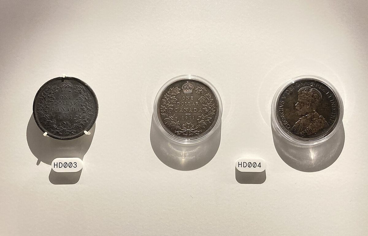 The three strikes of the 1911 Canadian silver dollar on display at the Bank of Canada Museum. The left coin is a trial strike made of lead, 