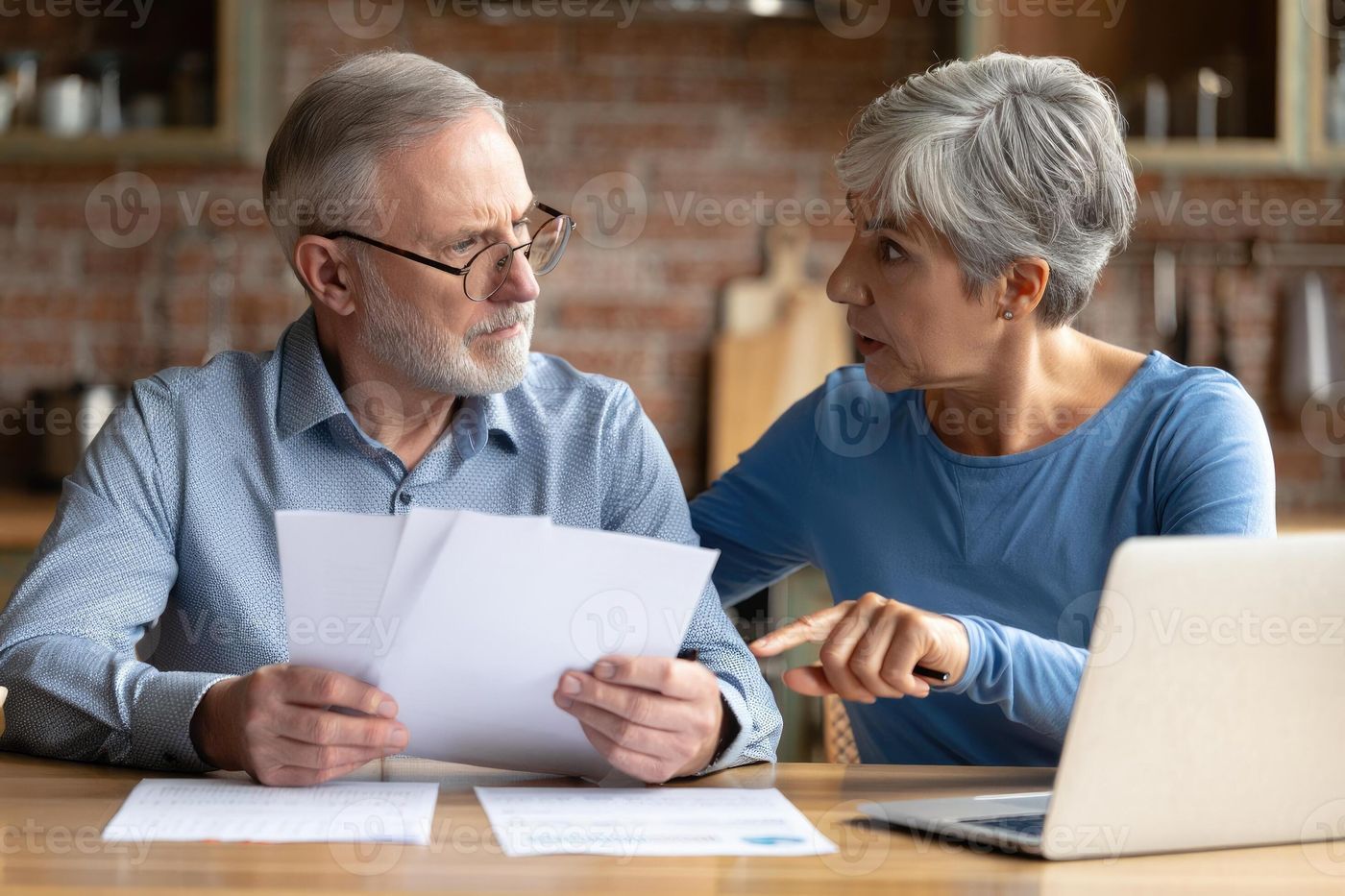 An older couple reviews finances, looking worried as they discuss their  bills and other paperwork at home. 70662554 Stock Photo at Vecteezy