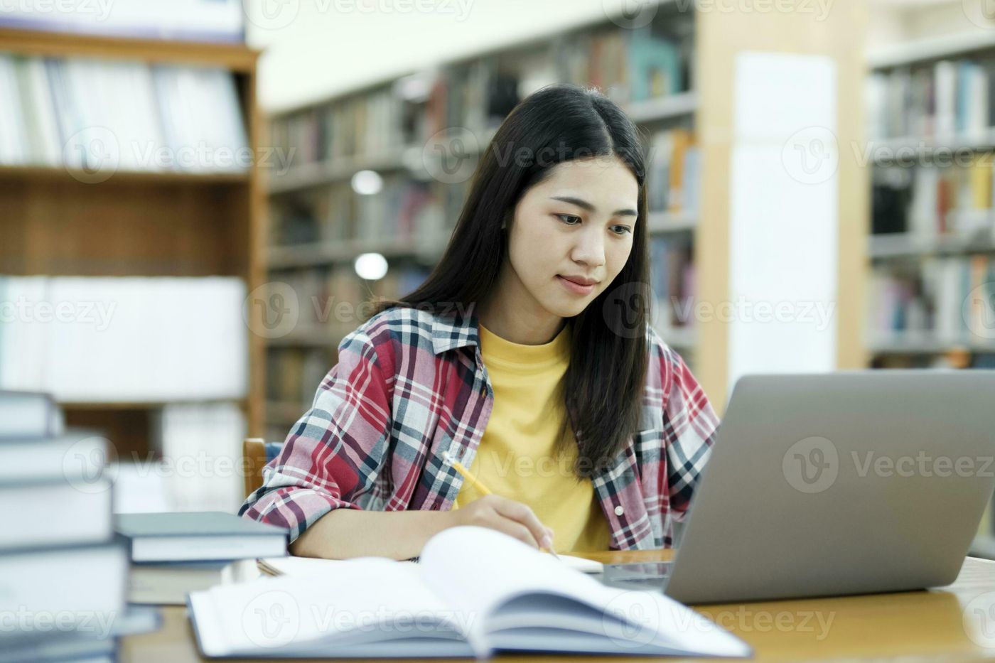 Young university student using laptop for online learning, searching and  learning at library. 27229989 Stock Photo at Vecteezy